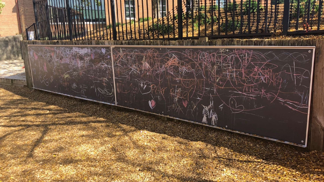 Chalkboards line this border wall to encourage creativity.