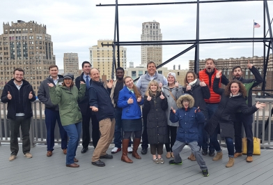 A group of OHM Advisors employees pose on a Detroit roof.