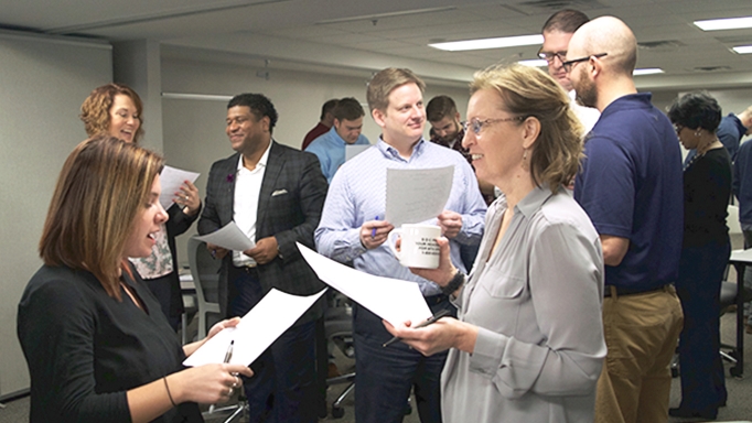Professionals stand and talk at a diversity and inclusion training event.