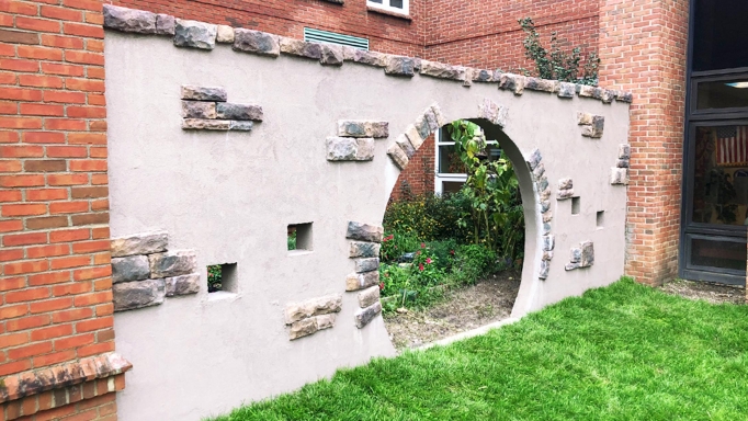 A rock wall invites children into a learning garden.
