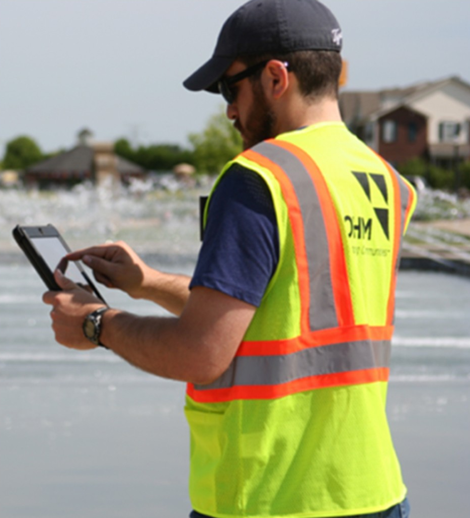 An OHM Advisors technician working in a community to identify and document service lines. 