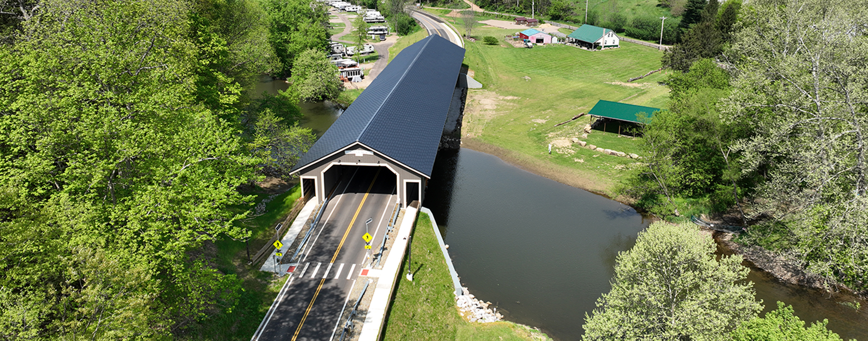 Two-lane covered timber bridge over the Mohican River.